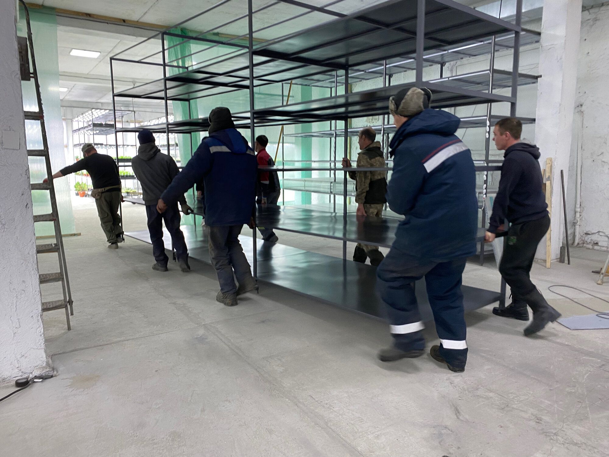 Командная работа: несут стеллаж